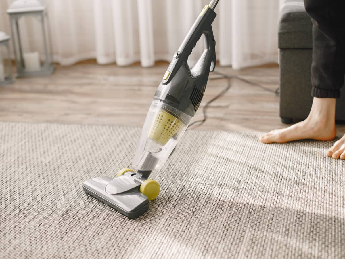 membersihkan karpet dengan vacuum cleaner